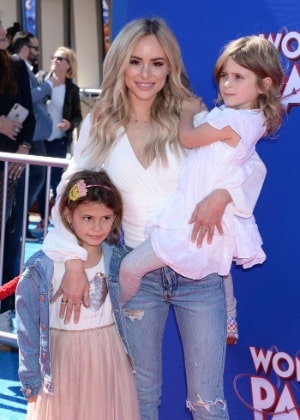 Kinsley Buonfiglio posing with her mom and sister by wearing blue jeans jacket and white vest.